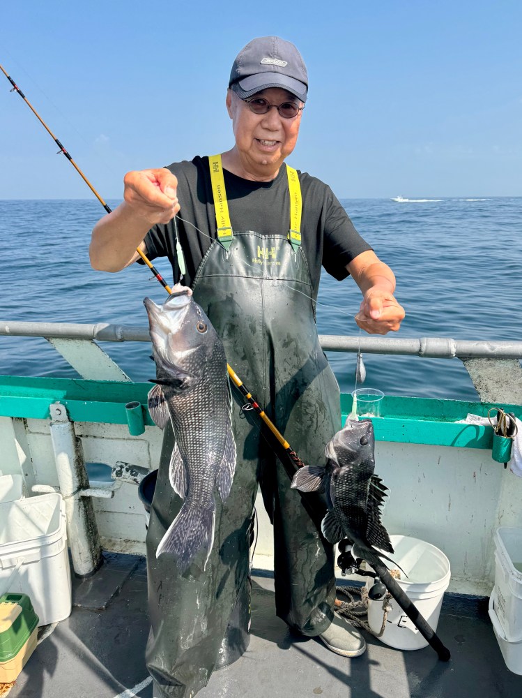 a man holding a fish on a boat in the water