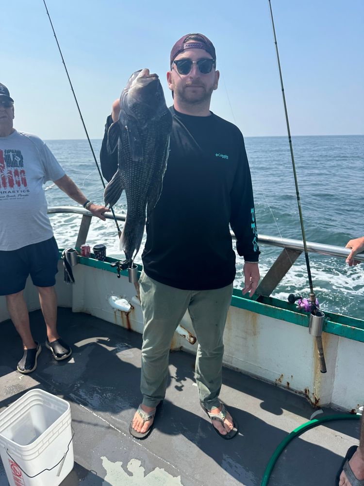 a person holding a fish on a boat in the water