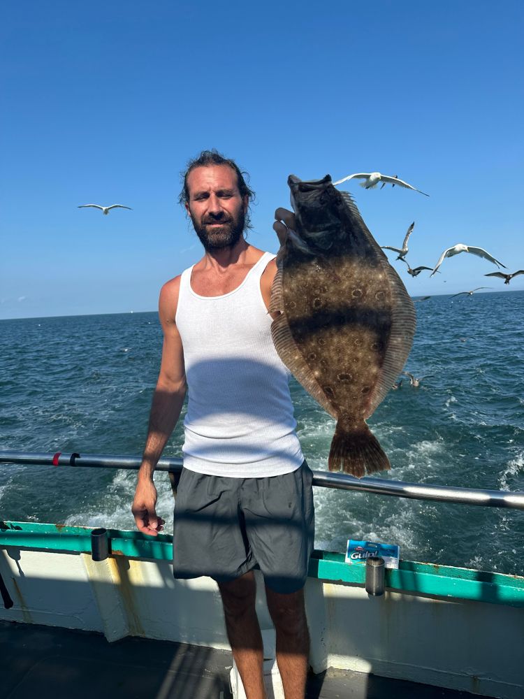 a man standing next to a body of water