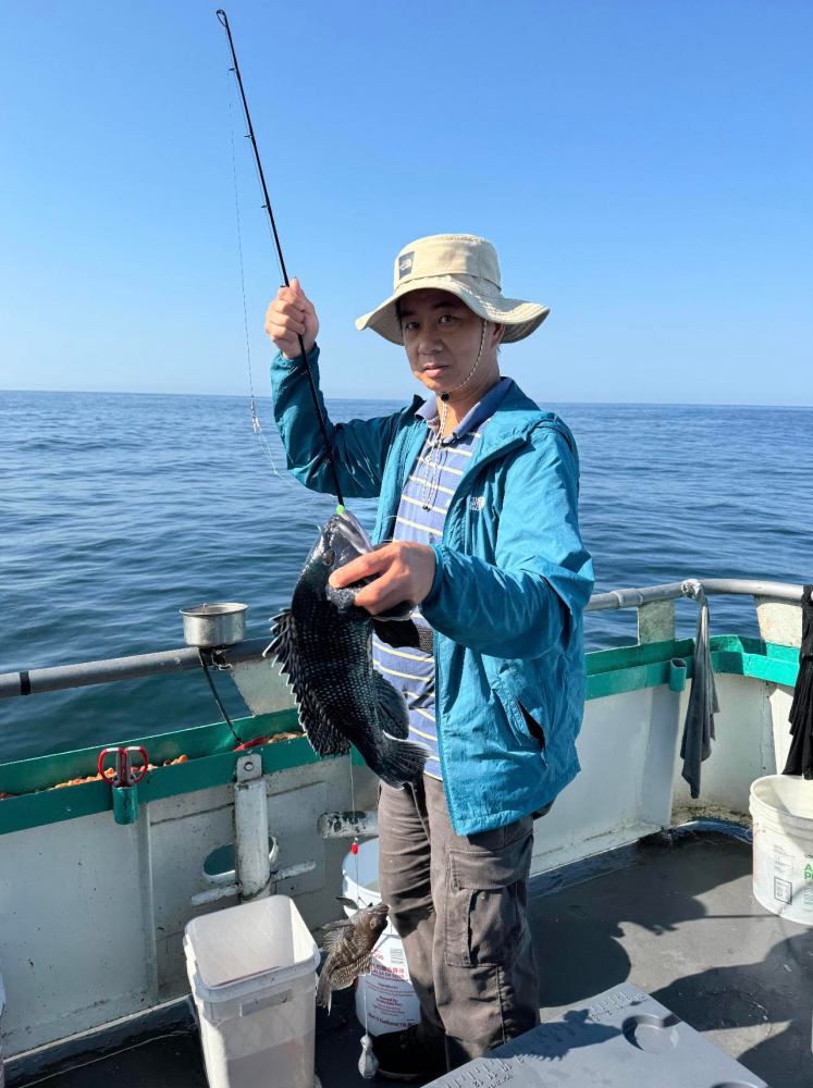 a person holding a fish on a boat in the water