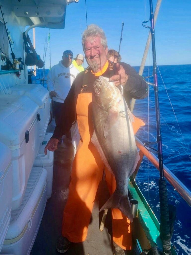 a man holding a fish in the water