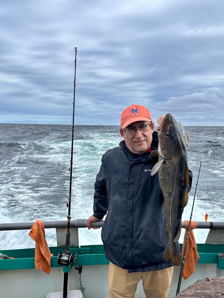 a person holding a fish on a boat in a body of water