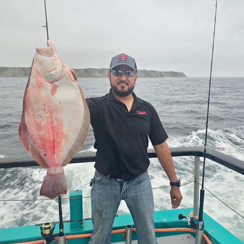 a man holding a fish on a boat