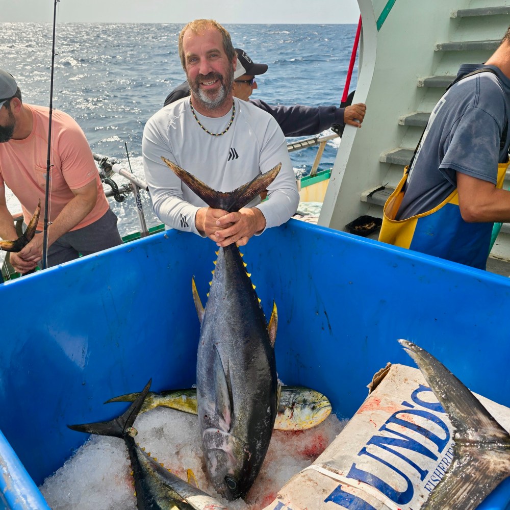 a man holding a fish on a boat