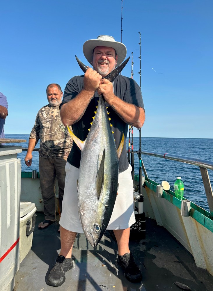 a person holding a fish on a boat