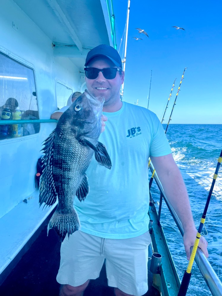 a man holding a fish on a boat