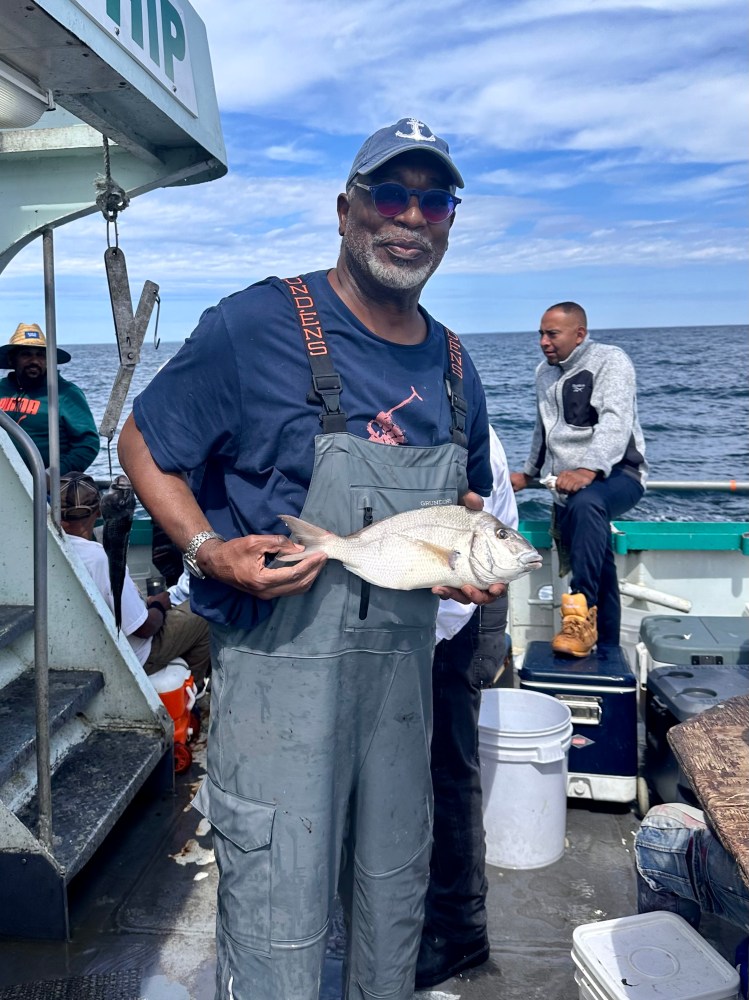 a man holding a fish in the water