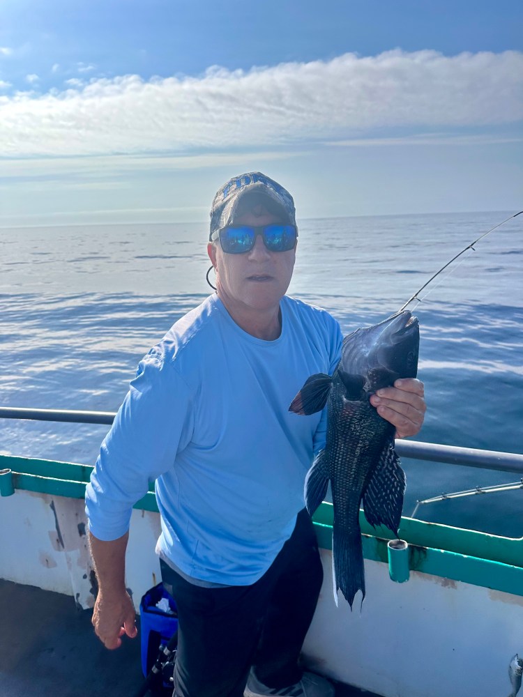 a man holding a fish in the water