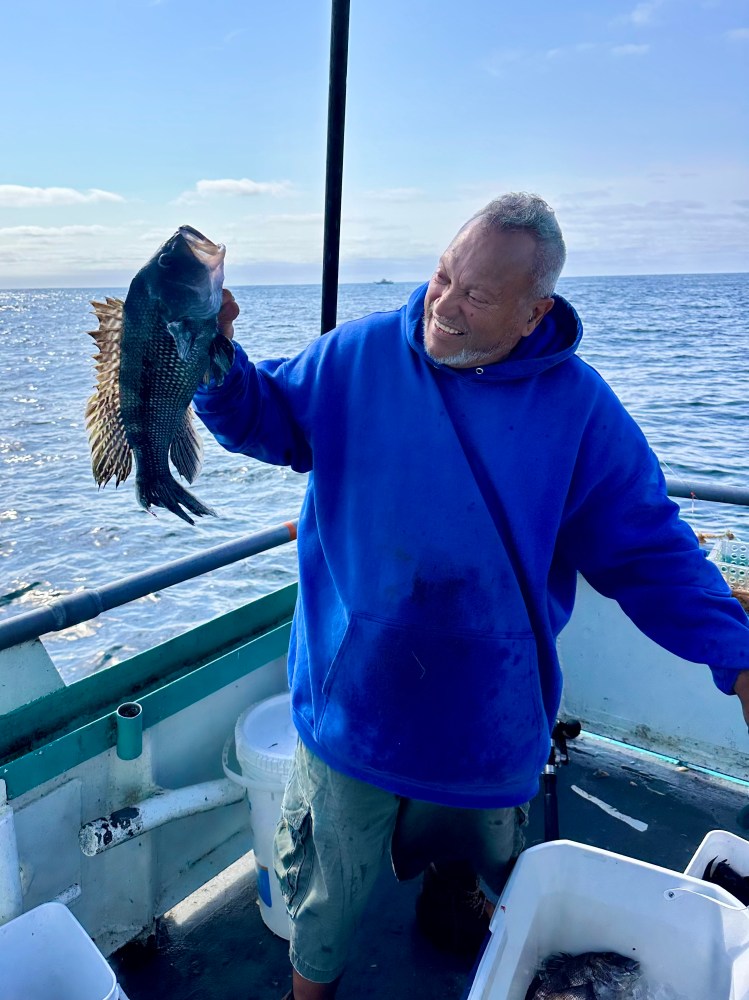 a man holding a fish in the water