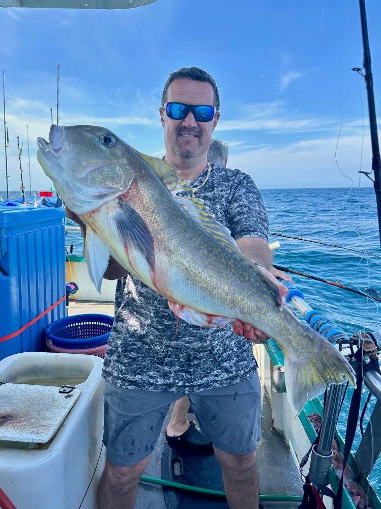 a man holding a fish in the water