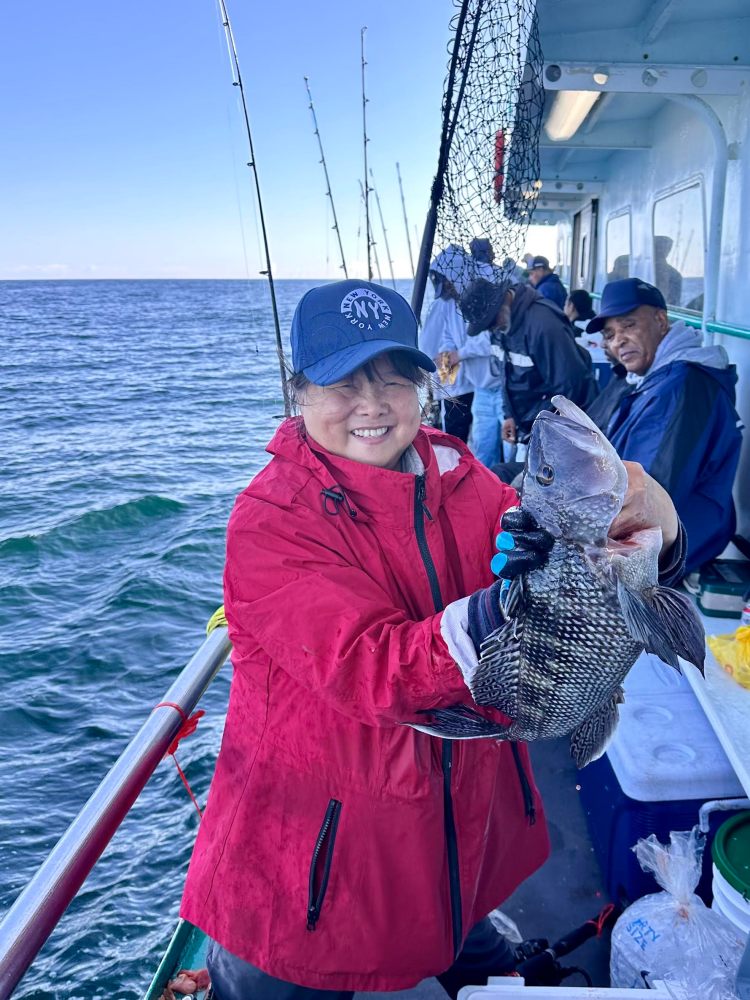 a person holding a fish on a boat in the water