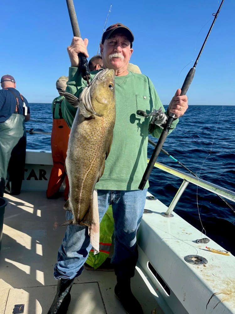 a man holding a fish on a boat