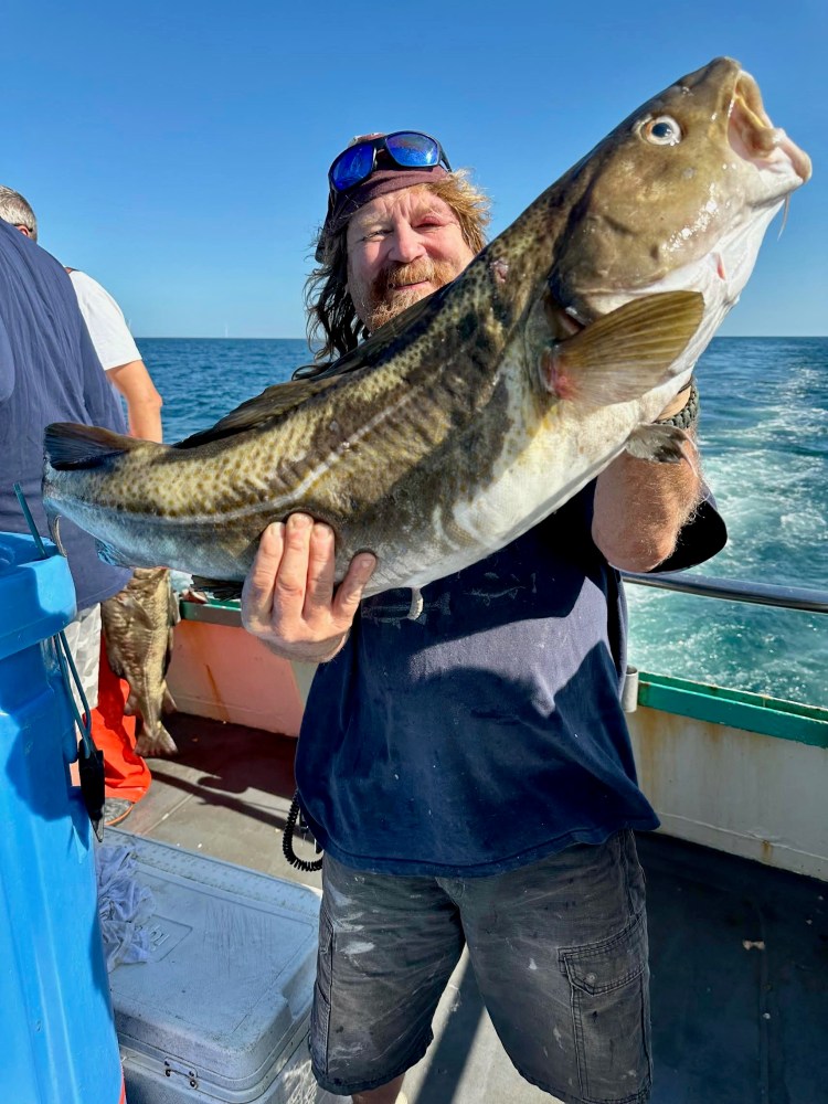 a person holding a fish in the water