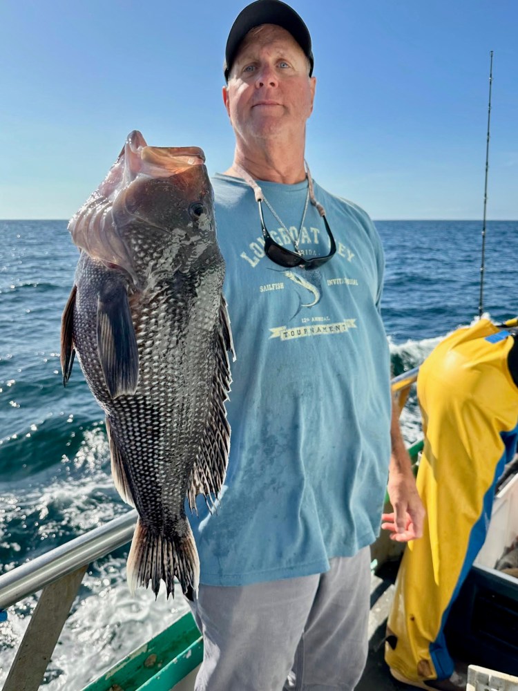 a man holding a fish in the water