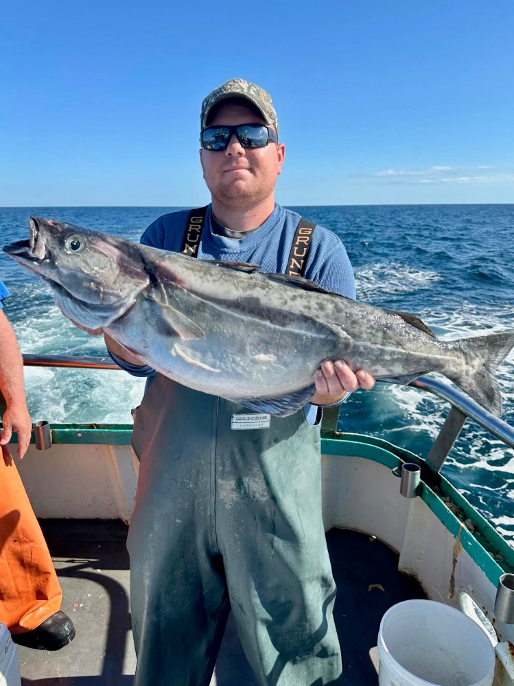 a man holding a fish in the water