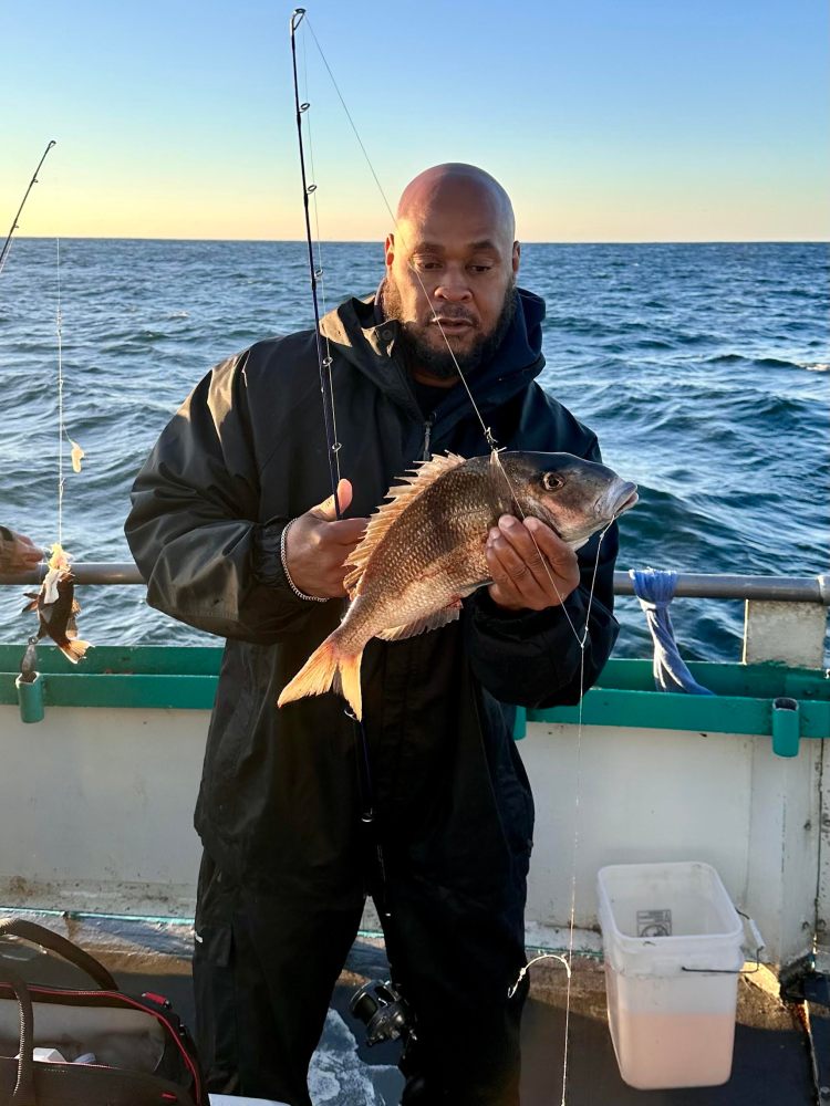 a person holding a fish on a boat in a body of water