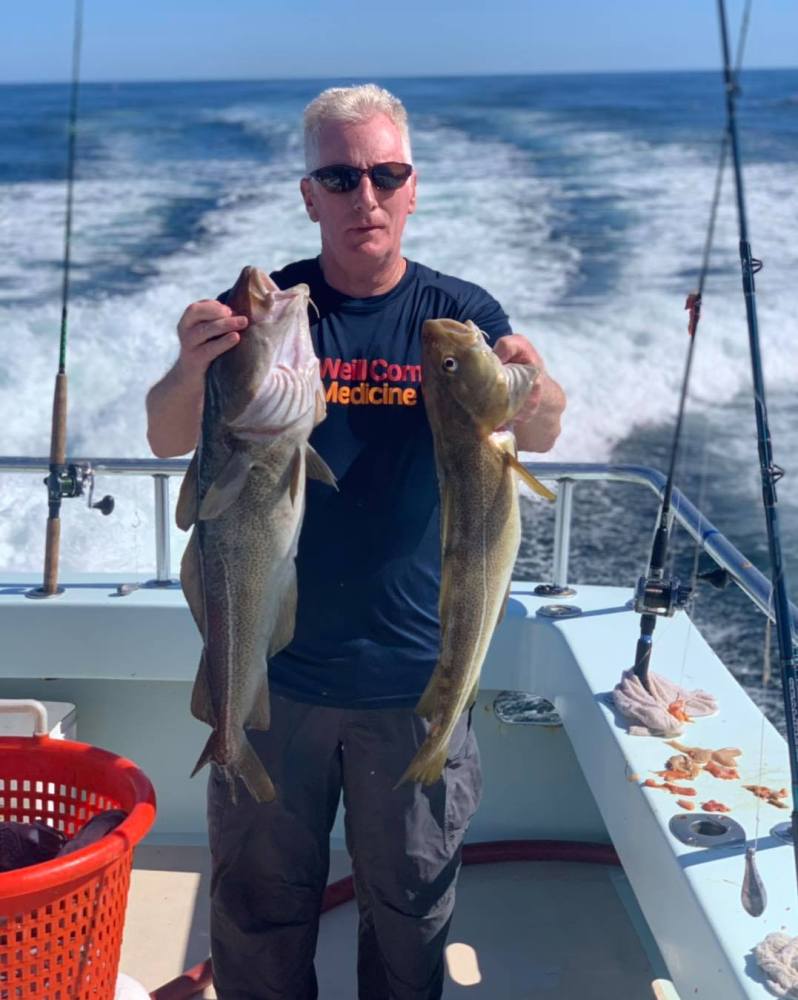 a man holding a fish in the water