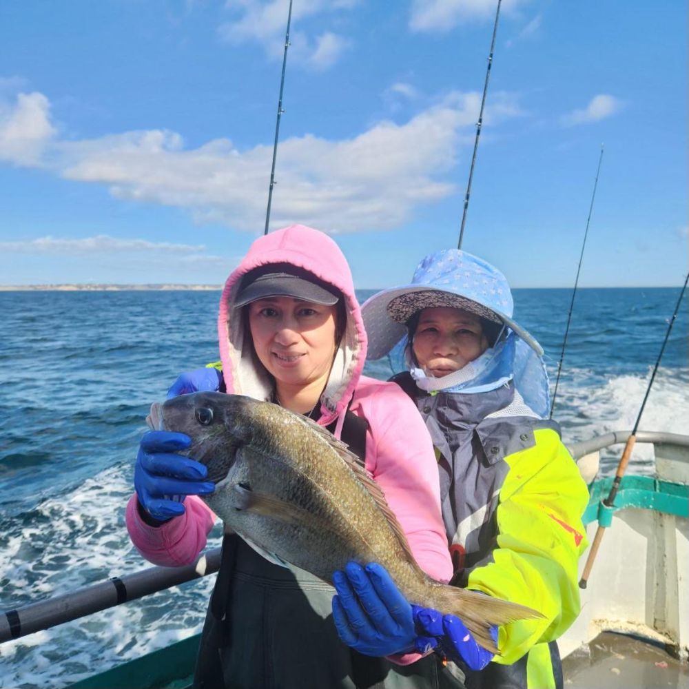 a person holding a fish on a boat in the water