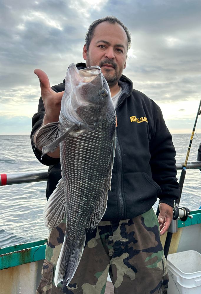 a man holding a fish in the water