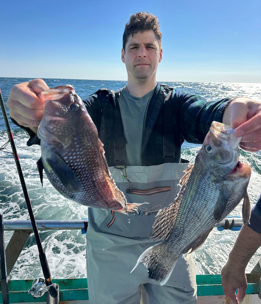 a man holding a fish in the water