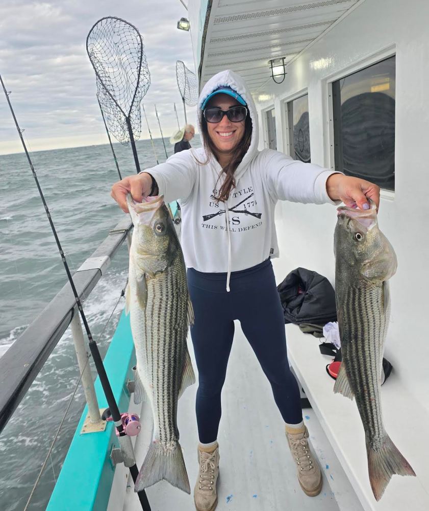 a person holding a fish posing for the camera