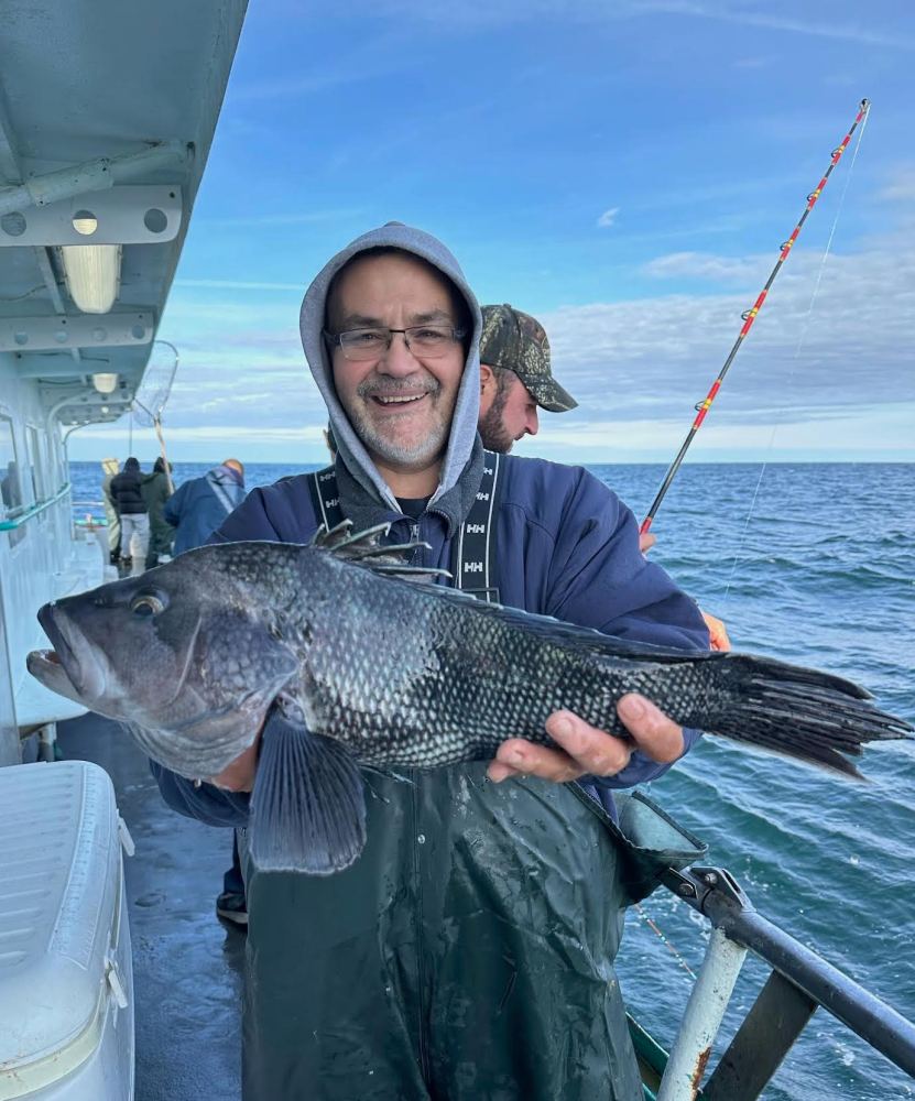 a man holding a fish on a boat