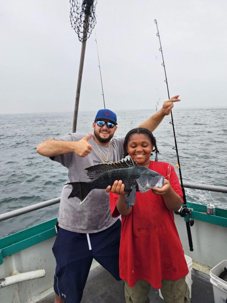 a person holding a fish on a boat in the water