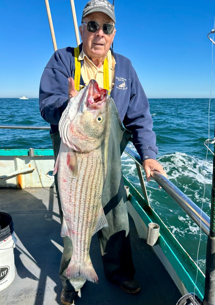 a person holding a fish on a boat in the water