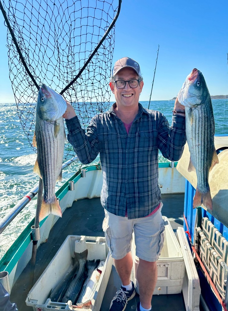 a person holding a fish on a boat