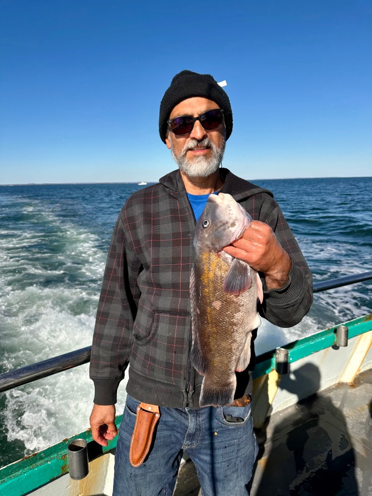 a man standing next to a body of water