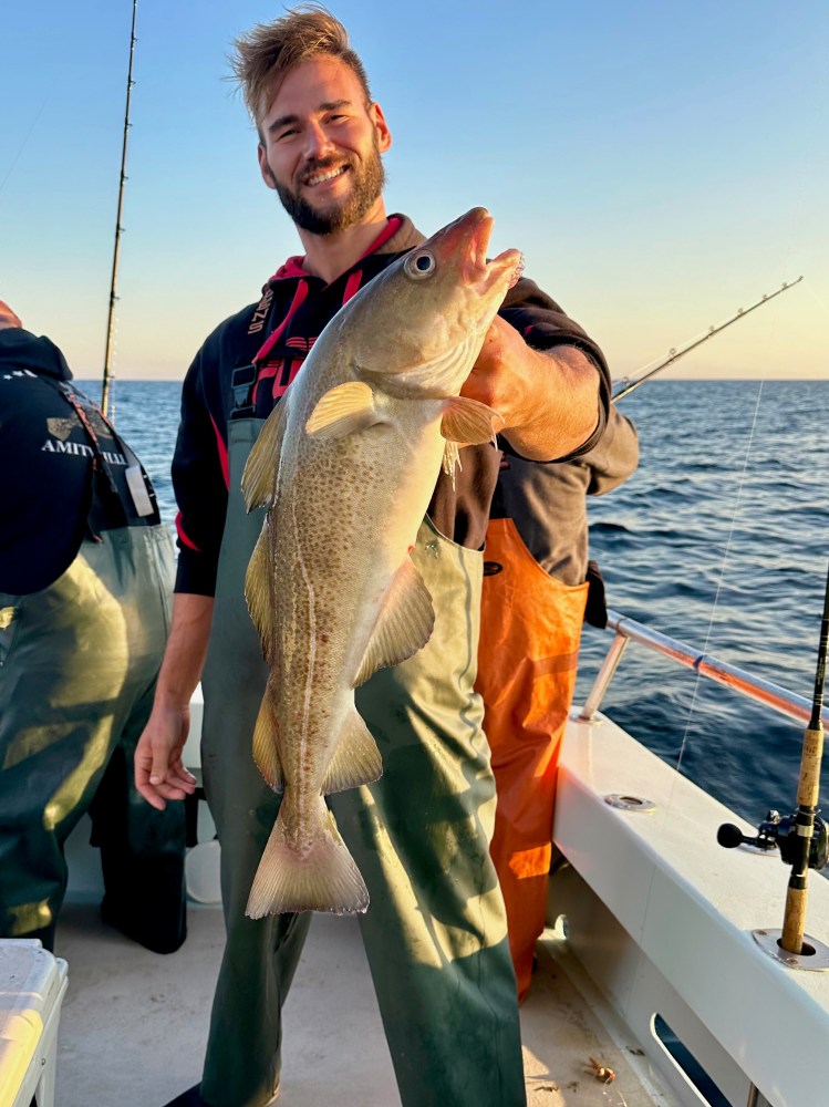 a man holding a fish in the water