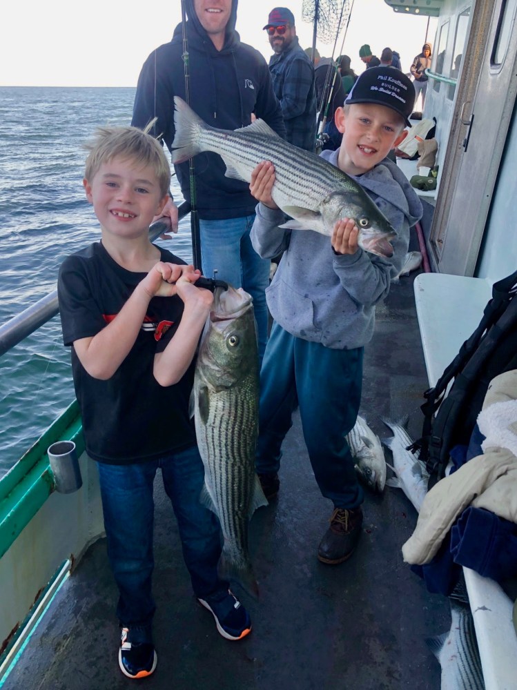 a young boy holding a fish