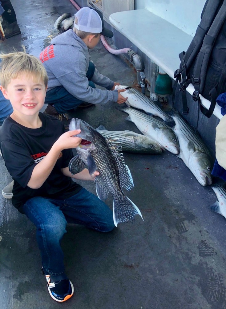 a young boy holding a fish