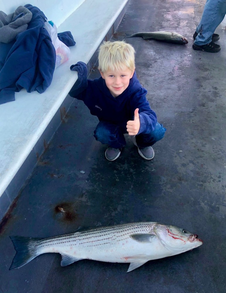 a young boy holding a fish