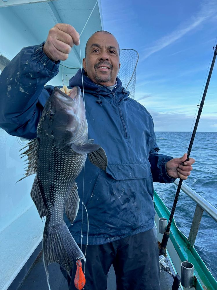 a man holding a fish on a boat