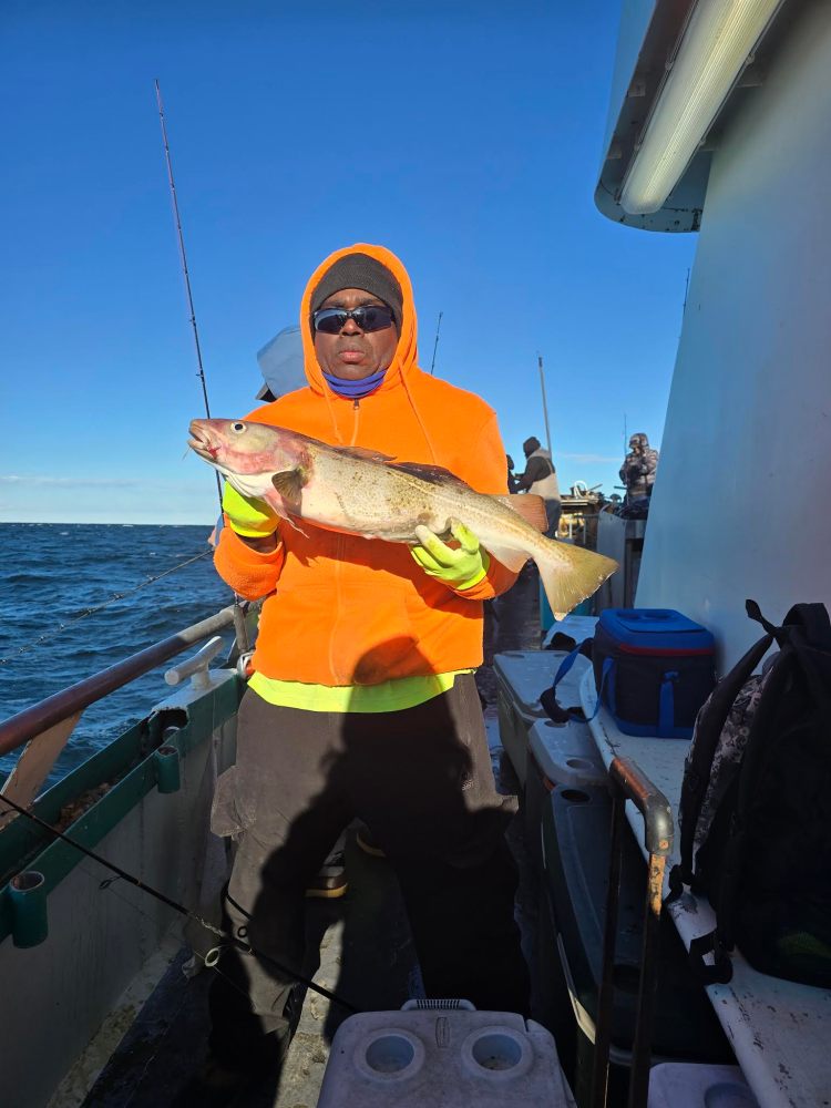 a person holding a fish on a boat