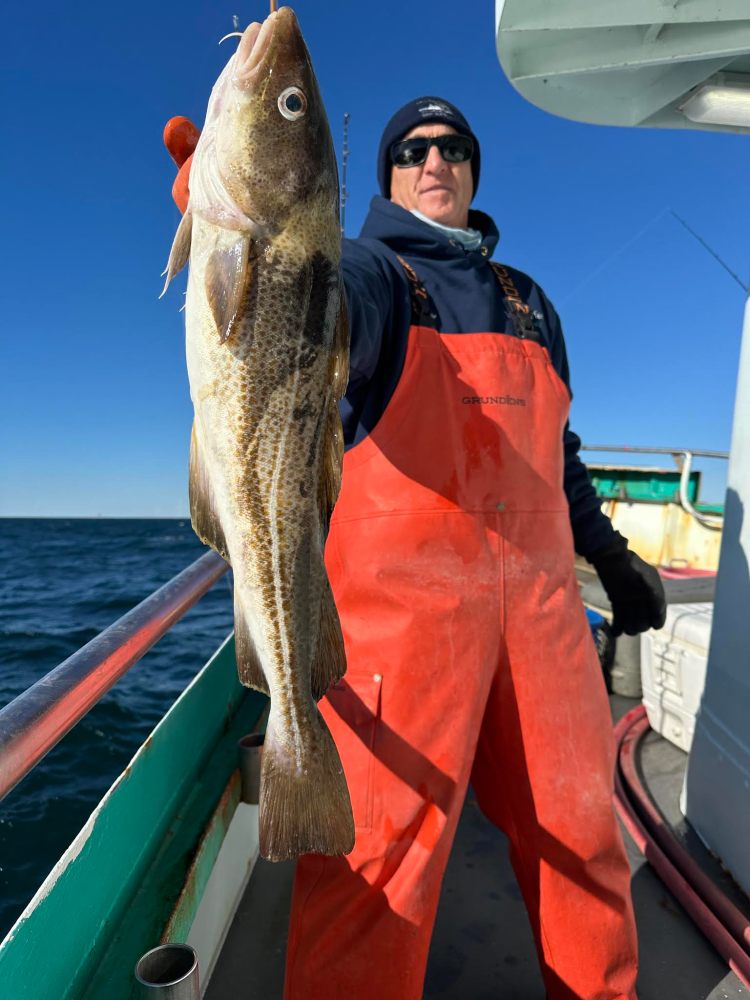 a man holding a fish on a boat