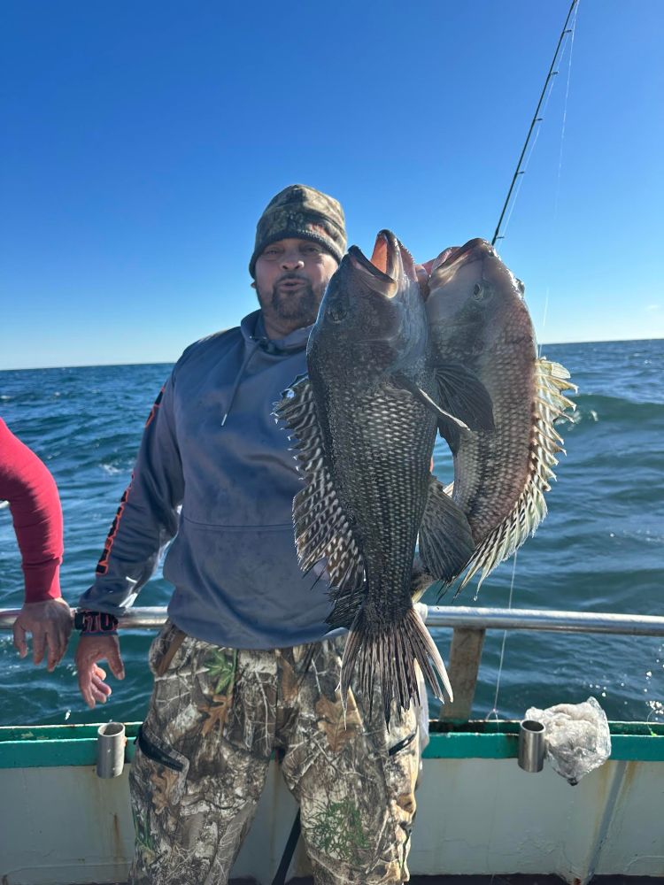 a man holding a fish on a boat in a body of water