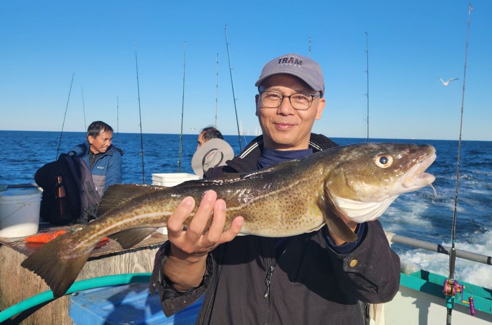 a person holding a fish on a boat