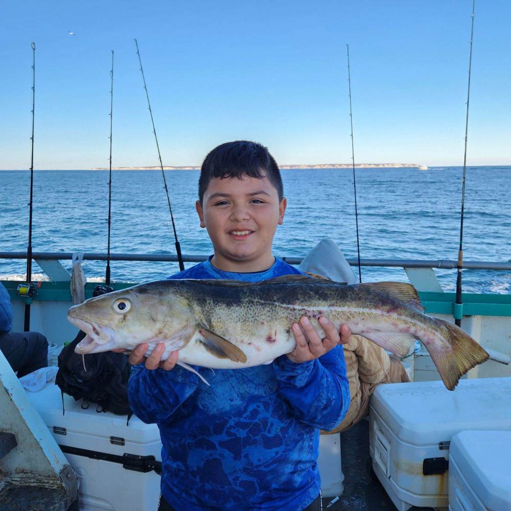 a person holding a fish on a boat in a body of water