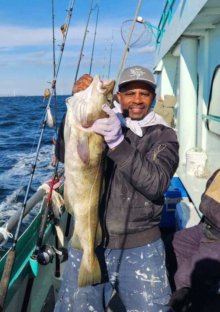 a man holding a fish on a boat