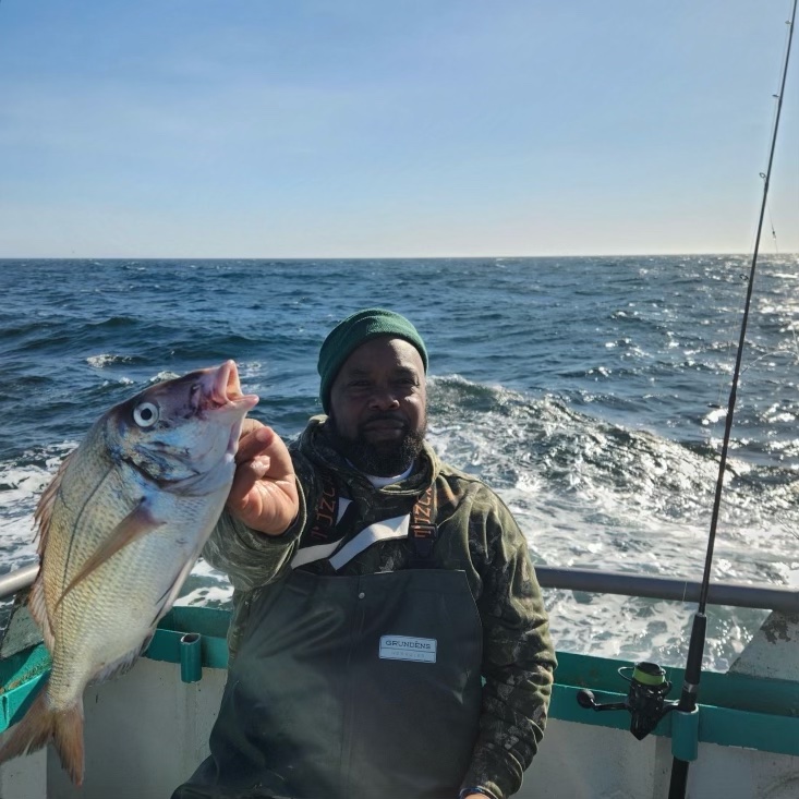 a person holding a fish in the water