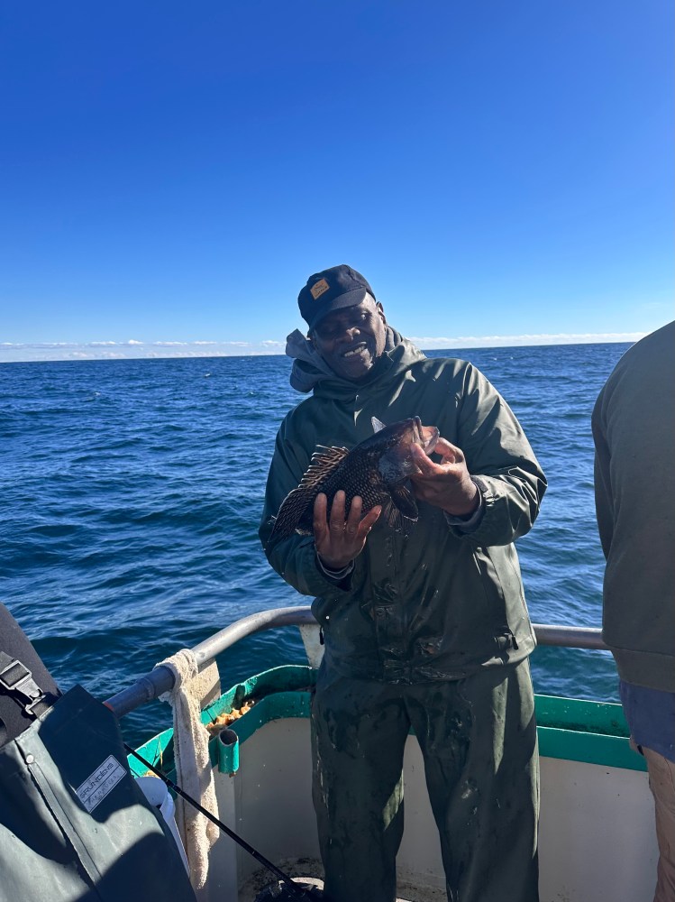 a man standing next to a body of water