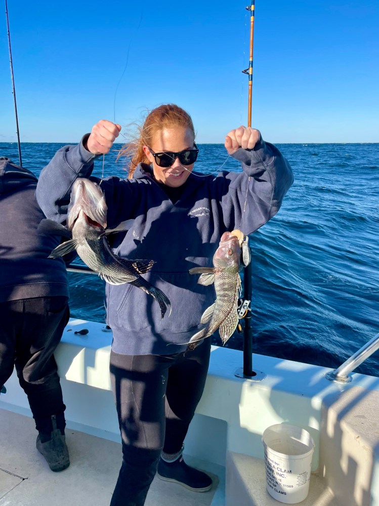 a person holding a fish on a boat in the water