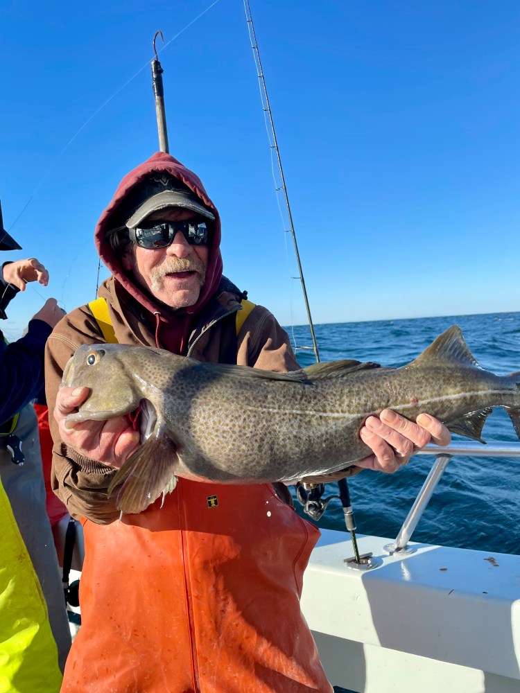 a person holding a fish on a boat