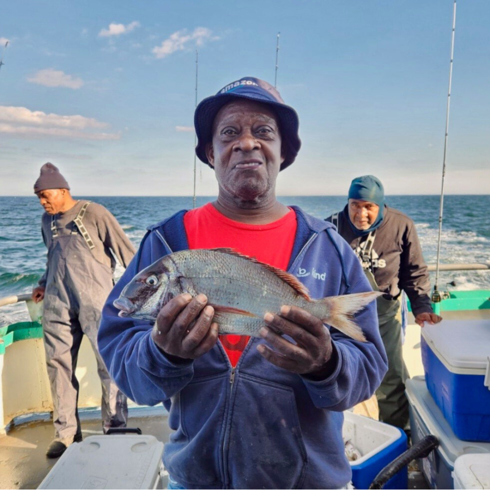 a man holding a fish in the water