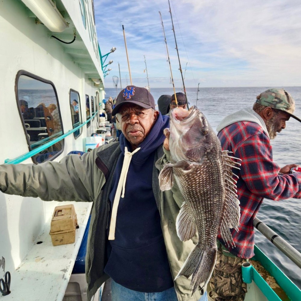 a group of people standing next to a person holding a fish