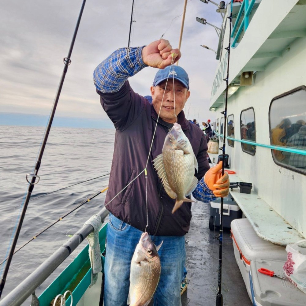 a man holding a fish on a boat