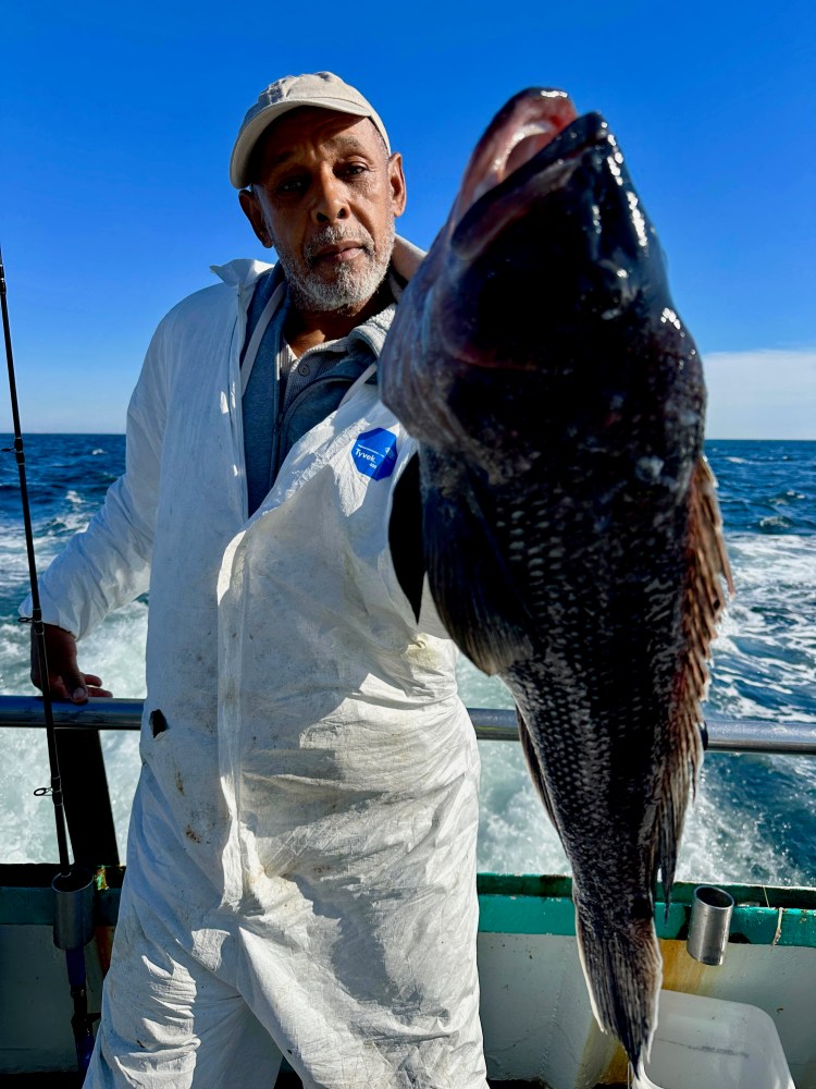 a man holding a fish in the water