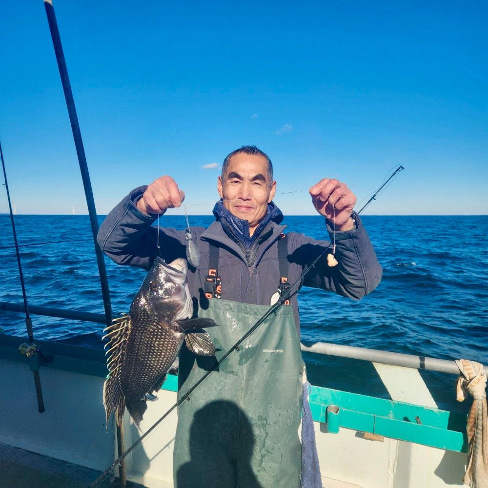 a person holding a fish on a boat in the water